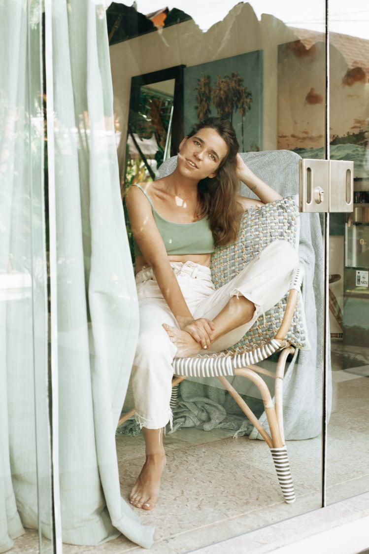 Woman in Green Tank Top Sitting on Woven Chair